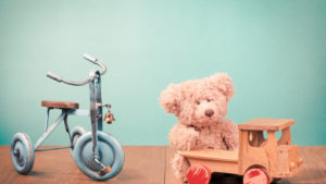 Old retro children's toys: bicycle, Teddy Bear, wooden car. Vintage style filtered photo