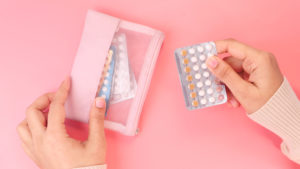 women hand golding birth control pills close up