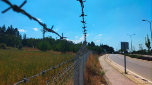 A fence with barbed wire as a symbol of limiting a person within the framework of the current state of affairs