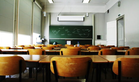 A large, empty classroom, lit by morning light.