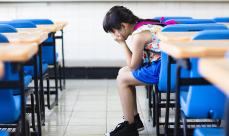 sad girl sitting and thinking in the classroom